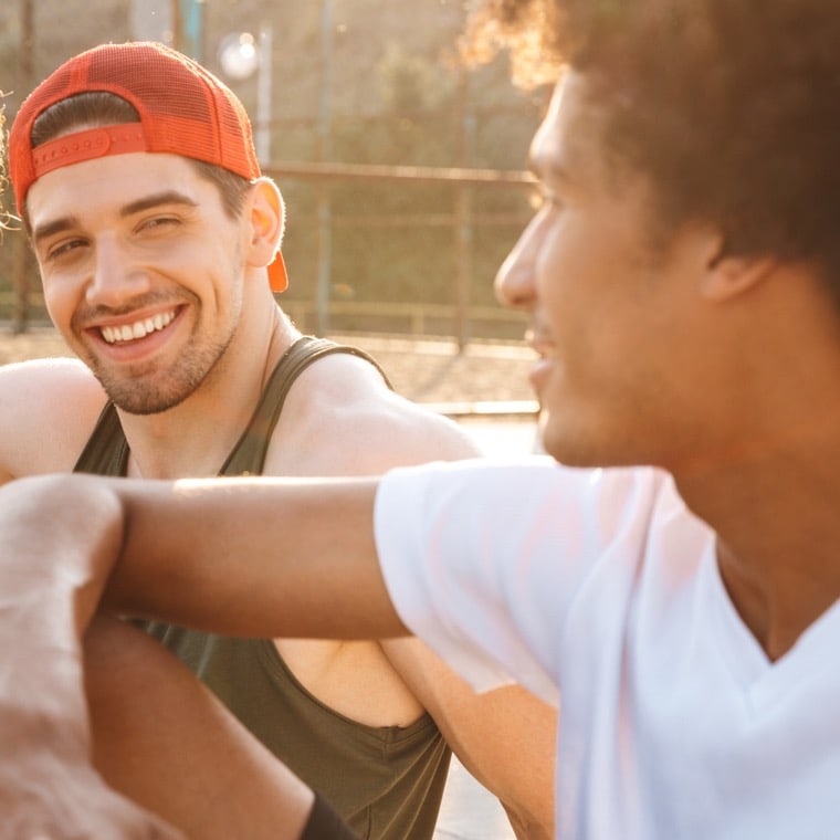 men smiling at basketball court